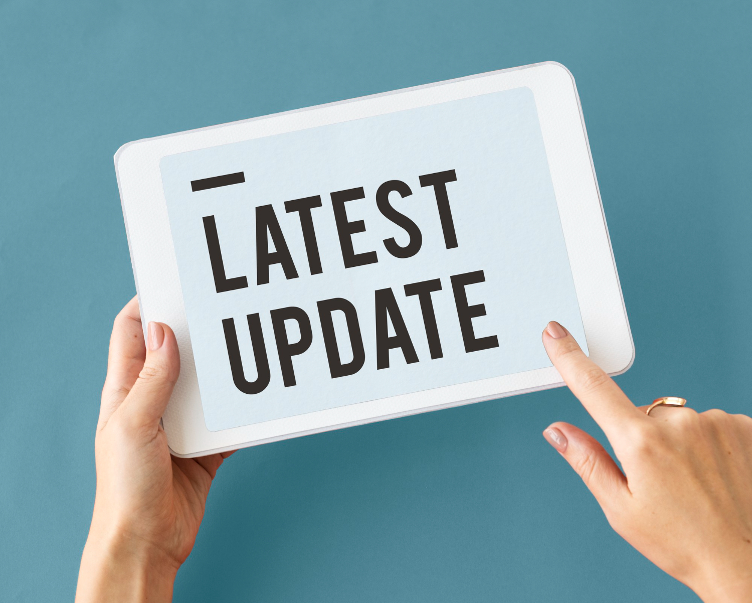 Image of someone holding a sign that says Latest Update.